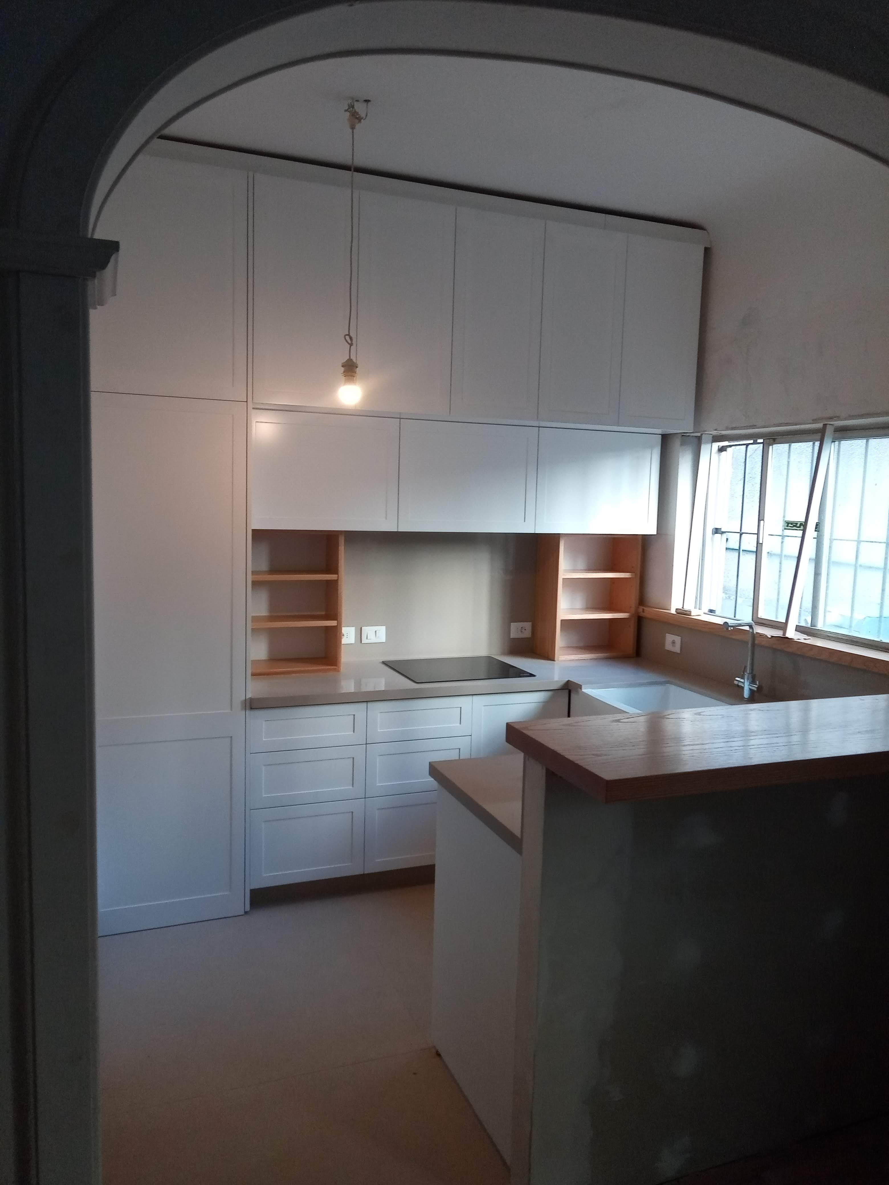 Cocina blanca a medida vista desde arco