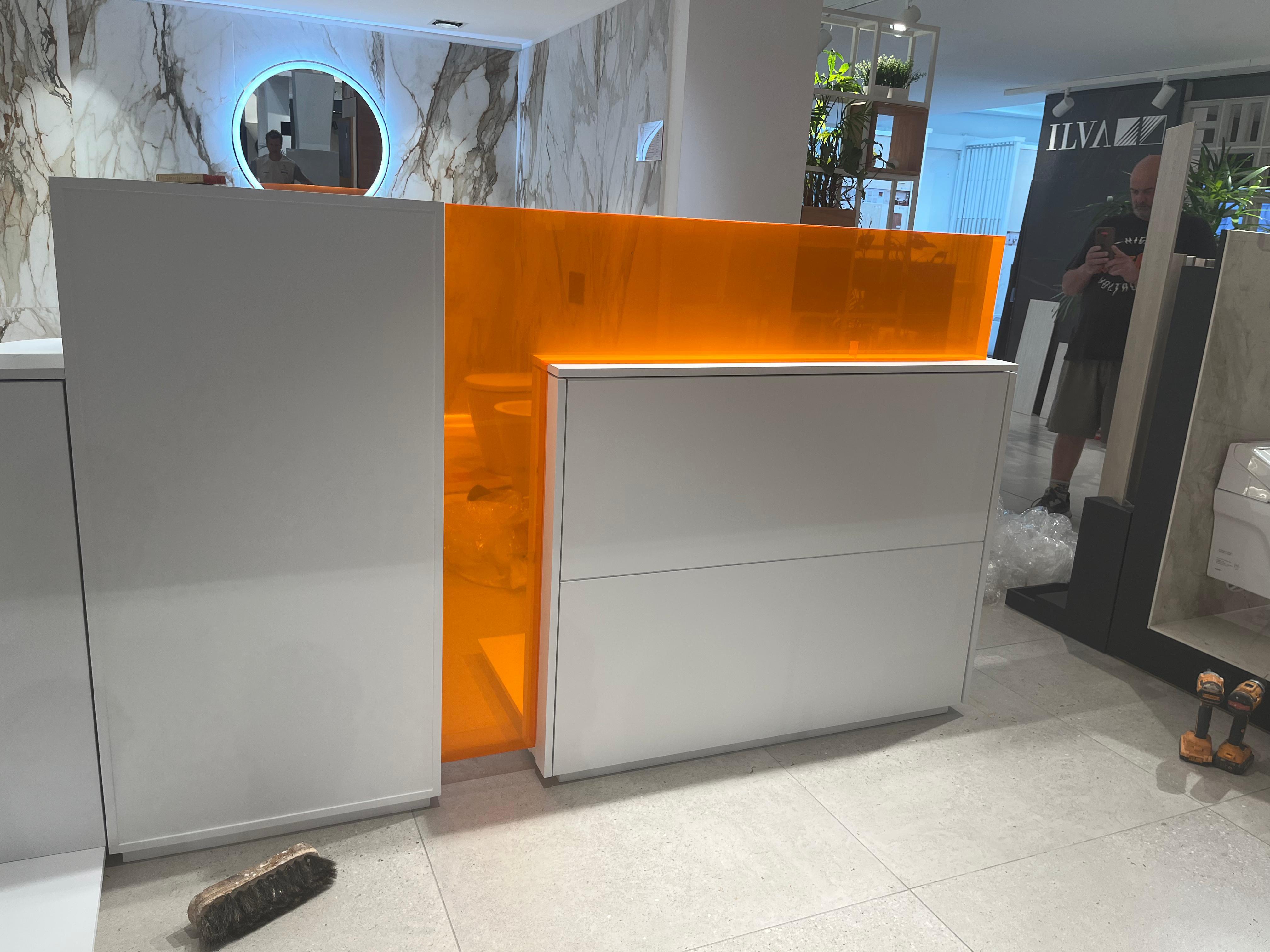 Mostrador ILVA con panel iluminado naranja - carpintería comercial