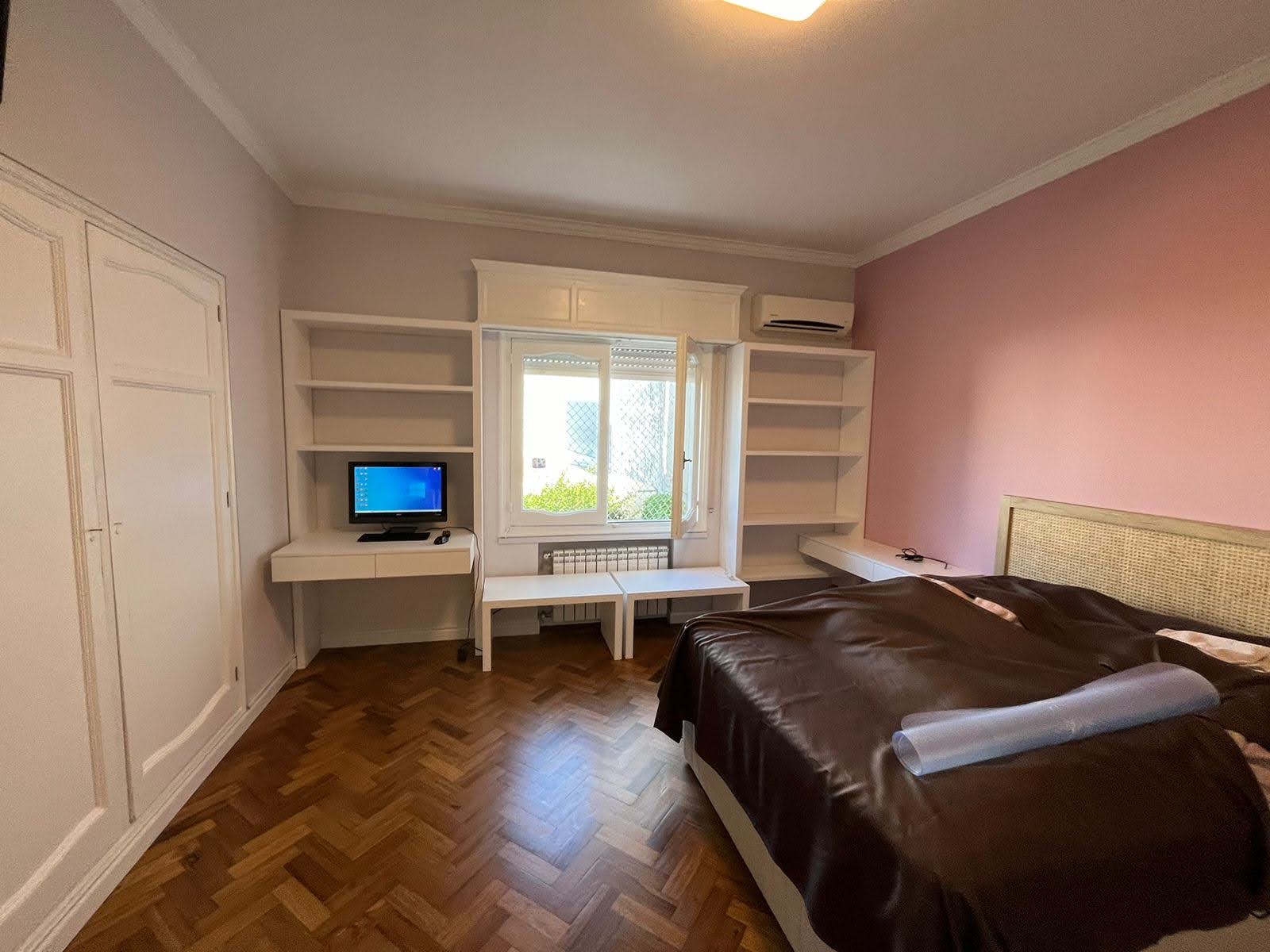 Dormitorio con escritorio y biblioteca integrada en madera